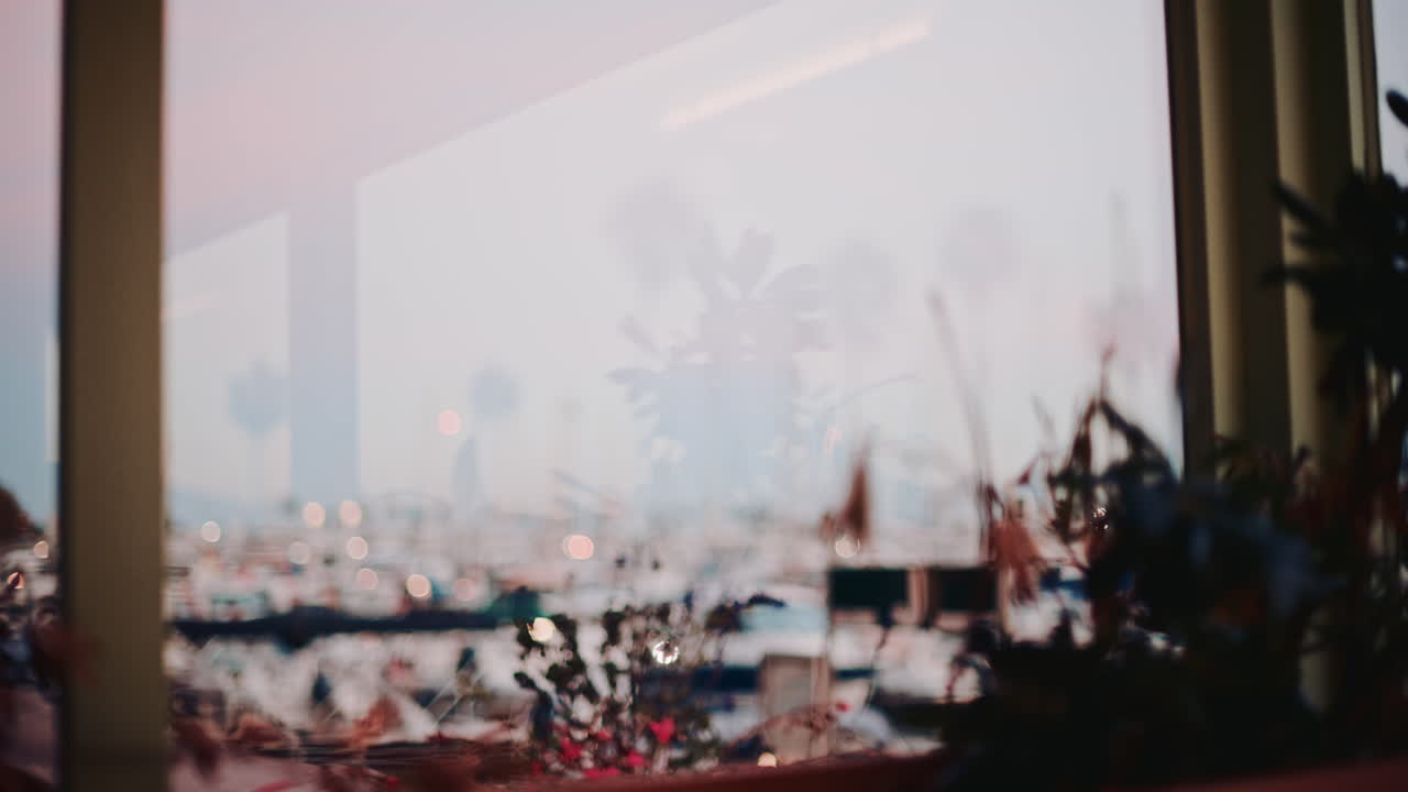 A woman pouring tea into a ceramic cup, filmed in warm evening tones