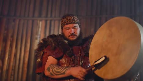 Bearded-man-taps-tambourine-to-communicate-with-spirits