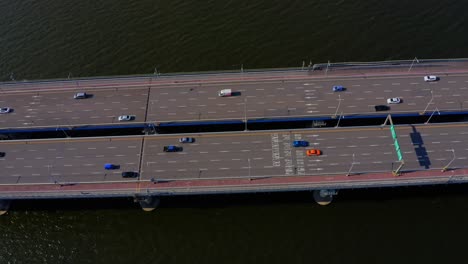 Drohnenschuss,-Der-über-Einer-Brücke-Fliegt,-Die-Einen-Fluss-Mit-Viel-Verkehr-überquert