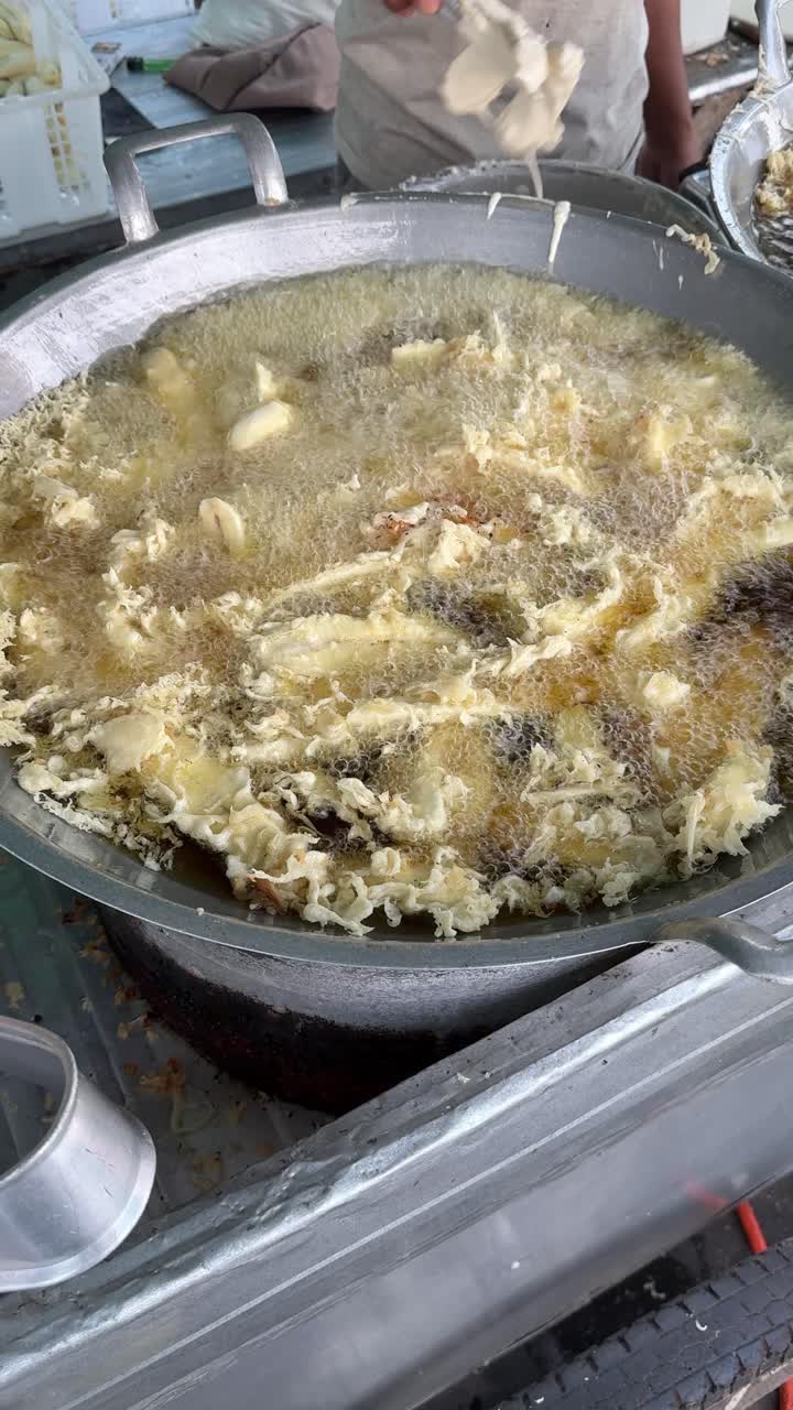 Person Deep Frying Crispy Fritters in Hot Oil