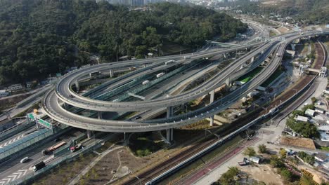 Traffic-on-a-Massive-highway-interchange-with-multiple-levels-and-loop-shaped-road-in-Hong-Kong,-Aerial-view