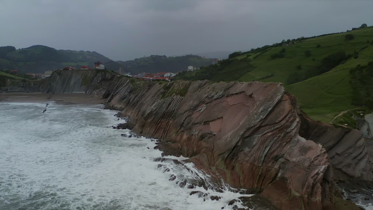 lento motino dolly en como las olas se estrellan en los bordes del acantilado en ángulo en itzurun zumaia españa