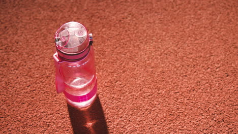 close up shot of a water bottle on a running track in an indoor sport facility