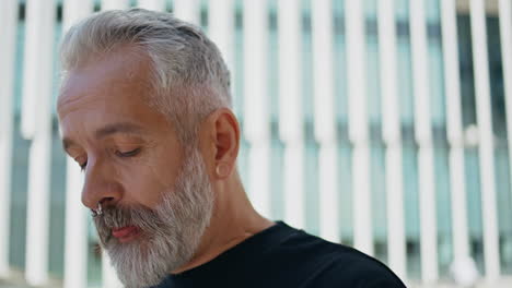 portrait mature man drinking morning coffee on street. brutal grey hair male