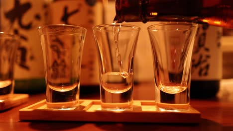 sequence of sake being poured into glasses