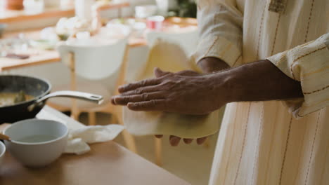 man cooking flatbread in a home kitchen