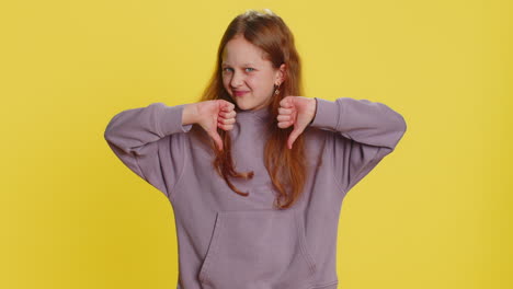 upset preteen child girl showing thumbs down dislike bad work disapproval dissatisfied feedback