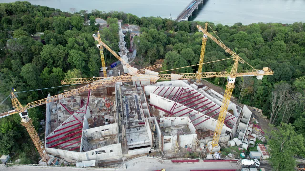 vista aérea construcción de un nuevo edificio con grúas de torre altas en área verde