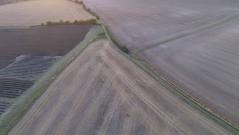 Slowly-flying-across-harvested-fields-to-reveal-hay-bales