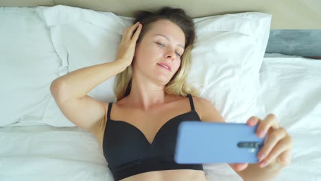 mujer tomando selfies en la cama