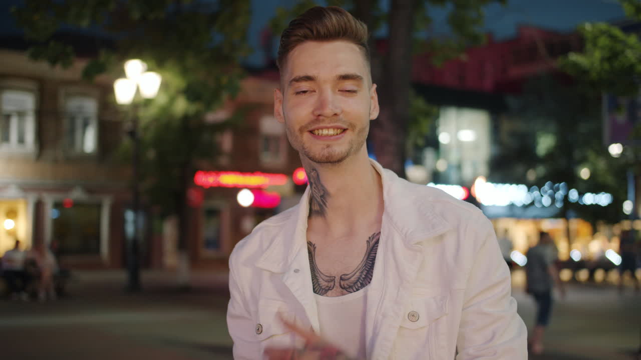 Smiling Man with Tattoos in a City at Night