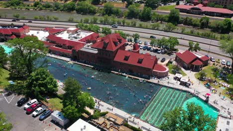 drone shot of people swimming in a pool at the glenwood hot springs resort, sunny colorado, usa