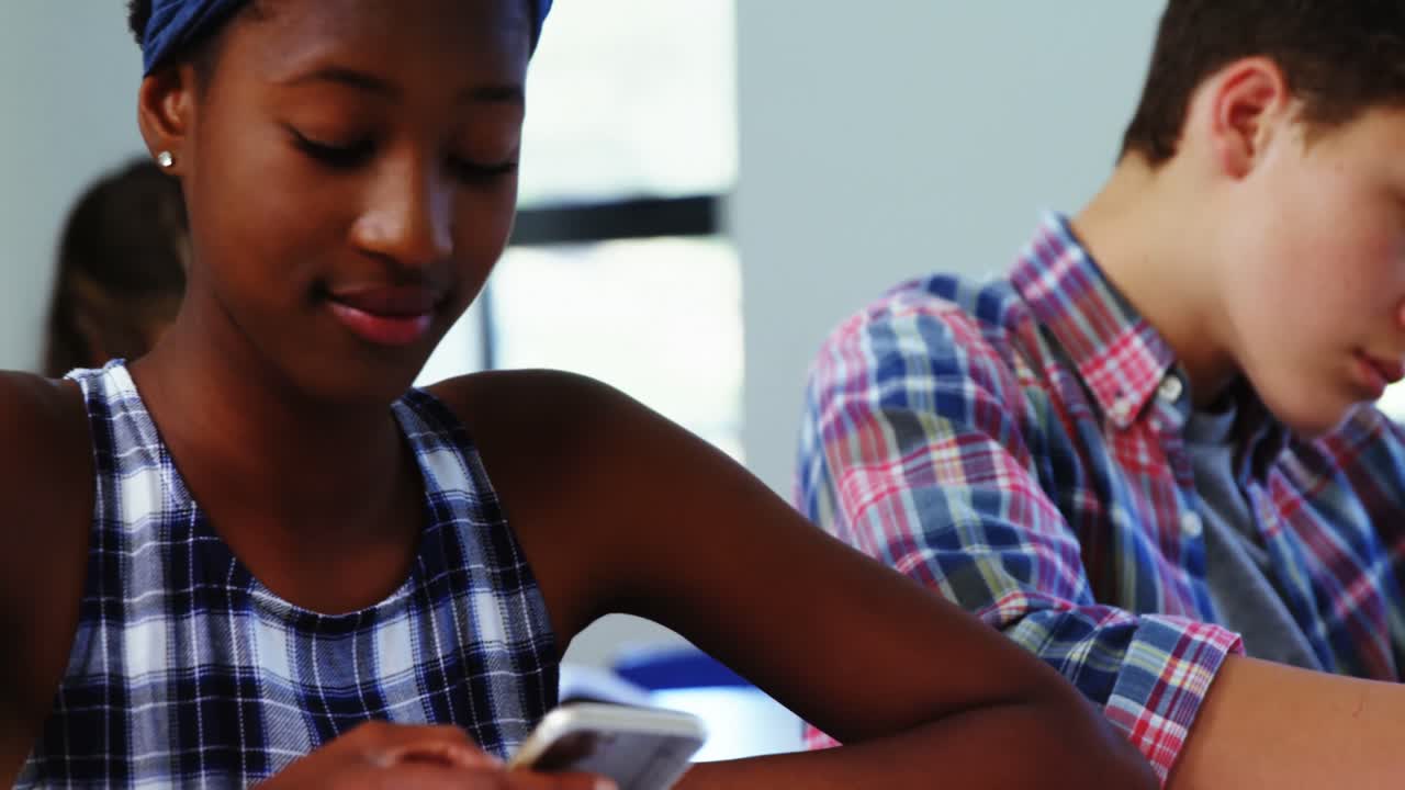 Student using mobile phone in classroom