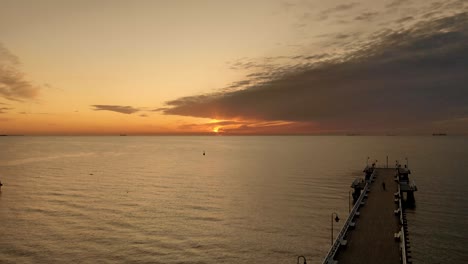 Slow-rise-over-a-wooden-bridge-over-the-sea-at-sunrise