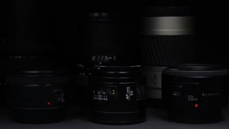 the light moves slowly over the camera lenses without visible brands on a black dark background