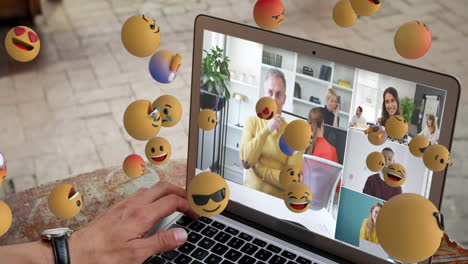 grupo de iconos emoji que fluyen sobre las personas en la computadora portátil.