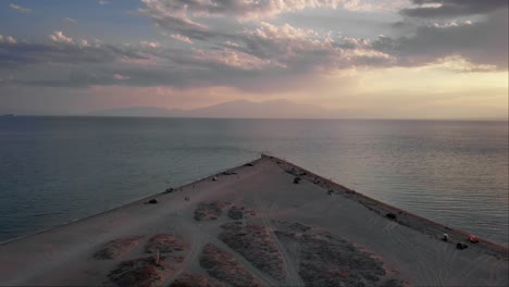 Orbit-Drone-video-dune-sandy-beach-mountain-Olympus-background-summer-sunset-Greece