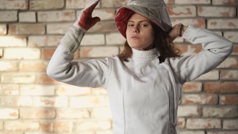 young woman fencer posing in fencing gear.