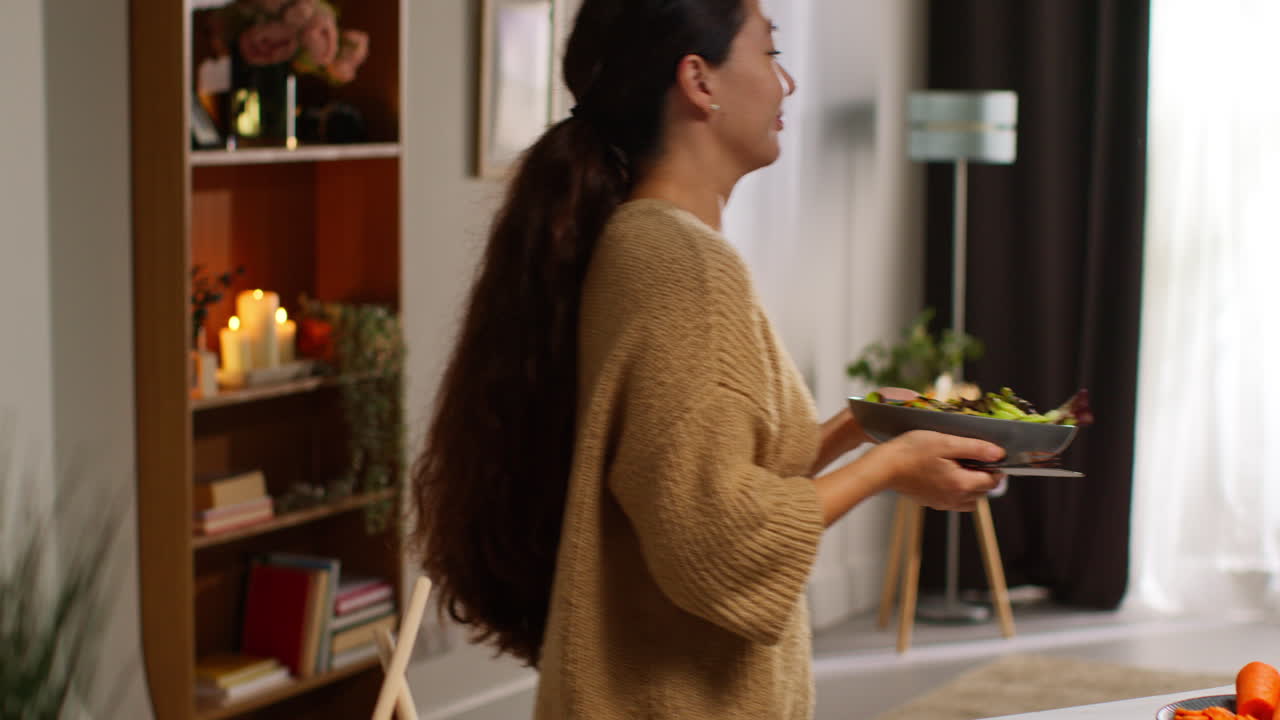 가정에서 부에서 건강한 채식주의자 또는 채식주의자의 식사를 준비하고 씨과 드레싱이있는 러드 잎의 그을 먹는 여성