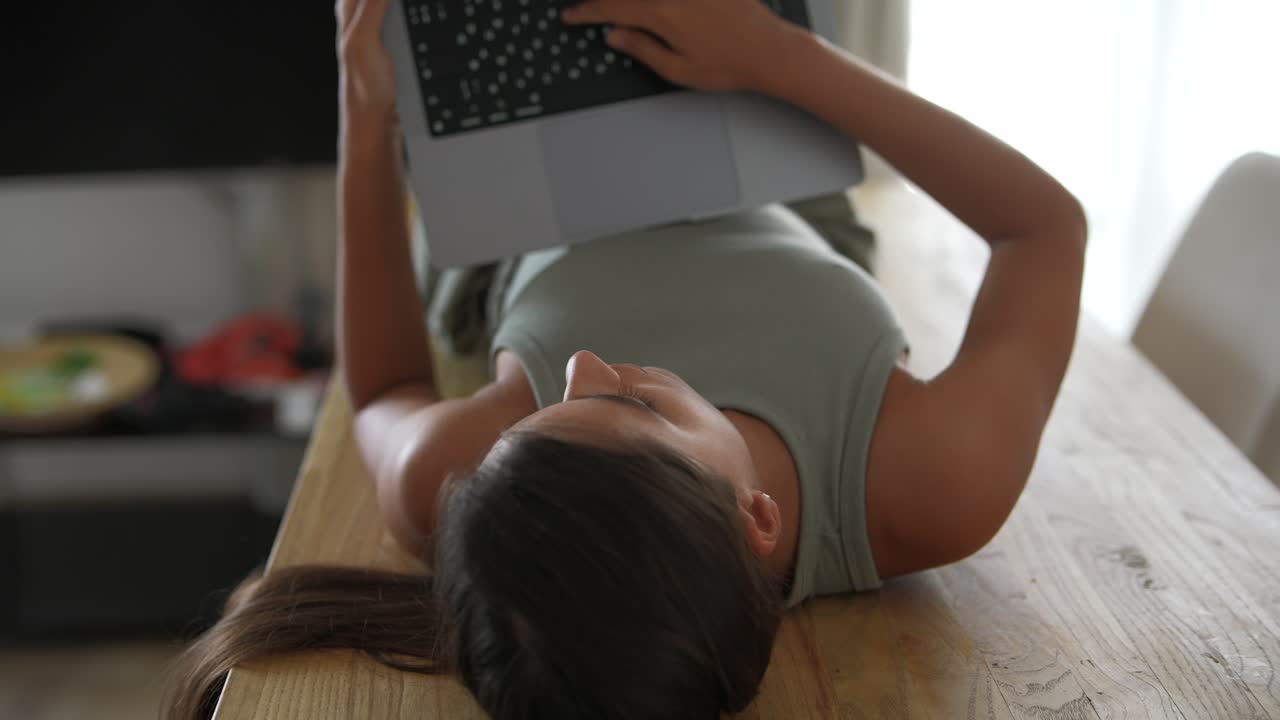 mujer trabajando en una computadora portátil acostada