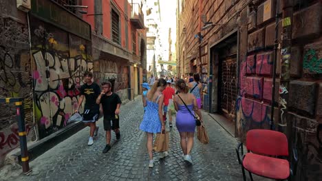 people walking in a vibrant, graffiti-filled alley