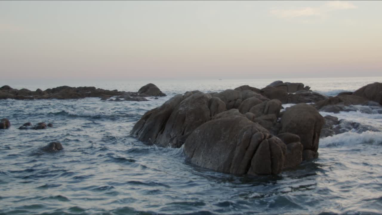 L'acqua si infrange sulle rocce al tramonto su una spiaggia in Portogallo 3