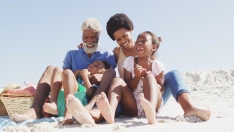 Glückliches-Afroamerikanisches-Paar-Umarmt-Sich-Mit-Kindern-Am-Sonnigen-Strand