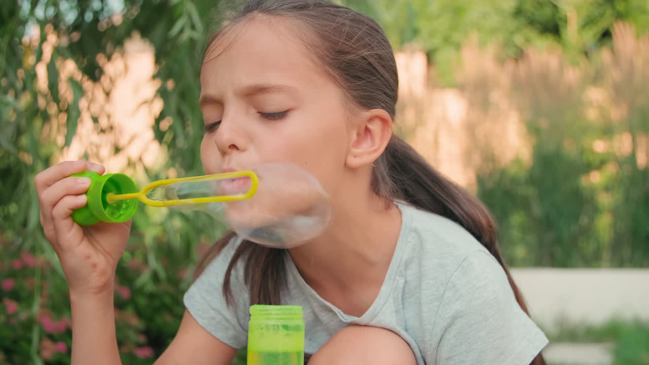 Beautiful Girl Blowing Soap Bubbles In Summer