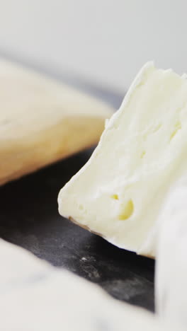 queso en rodajas, cuencos de mermelada y especias en tablero de madera