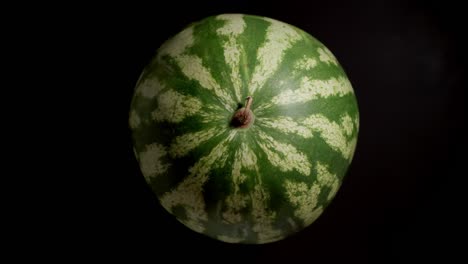 watermelon rotating on a black background, stop motion