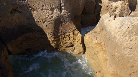 Agua-Del-Océano-Dentro-De-Formaciones-Rocosas-En-La-Costa-En-Algarve,-Portugal