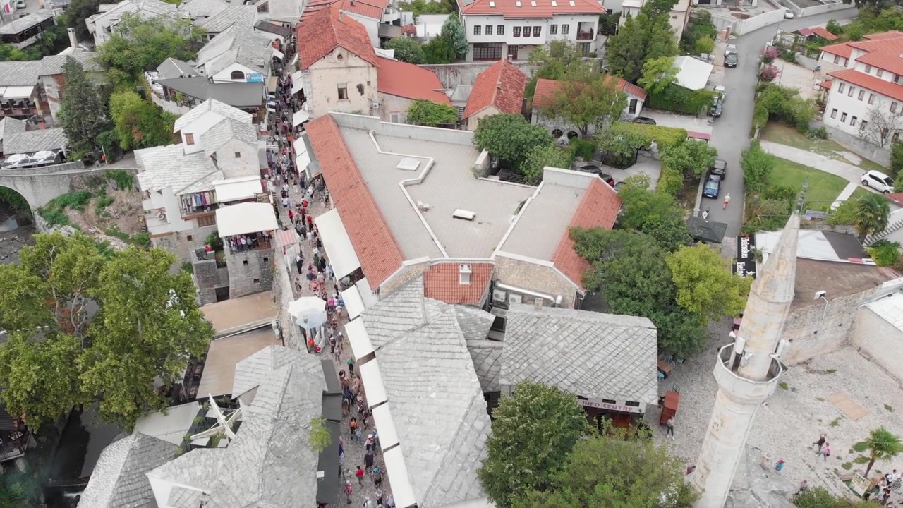 Luftaufnahme: Altstadt von Mostar mit Menschen in engen Gassen.