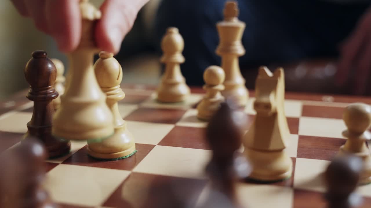 Close-up of a hand moving a chess queen on a wooden chessboard. Strategic gameplay in action, symbolizing decision-making, leadership, and competition. Perfect for business, strategy, success concepts