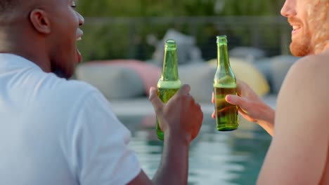 happy diverse friends with drinks cheering at pool in slow motion