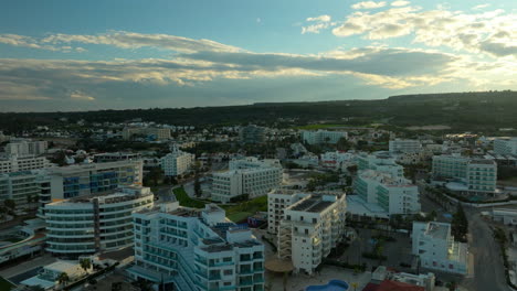 Vista-Aérea-De-Los-Hoteles-Y-Complejos-Turísticos-De-Lujo-De-La-Ciudad-De-Protaras-Al-Atardecer,-Chipre