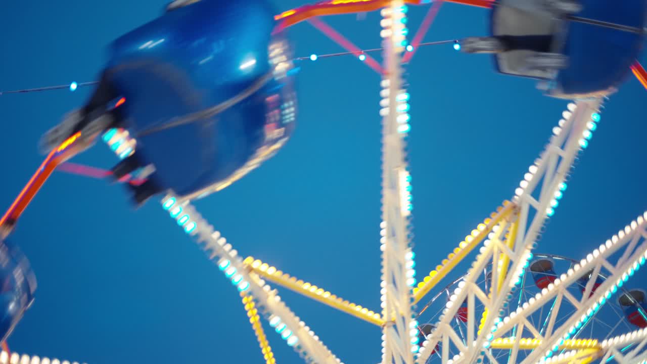 A Stunning View of a Colorful Ferris Wheel Against the Bright Blue Sky, Capturing the Joy and Excitement of a Carnival Atmosphere in Motion