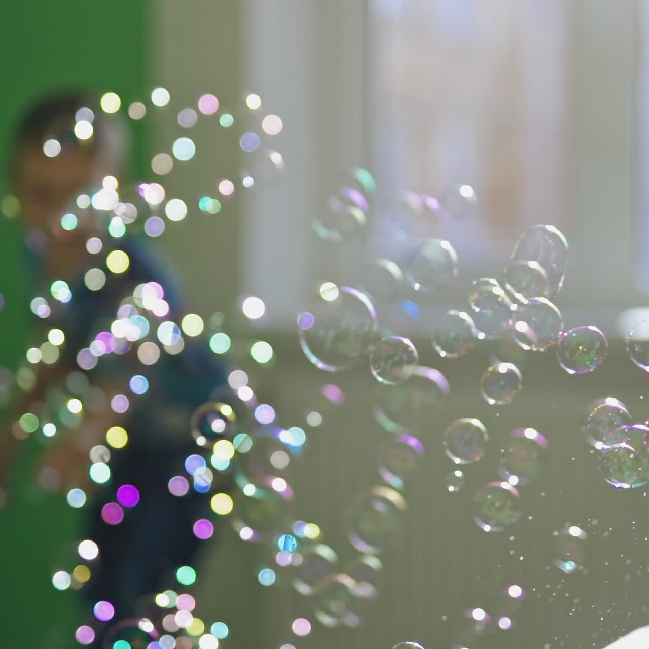 Energetic boy catching bubbles