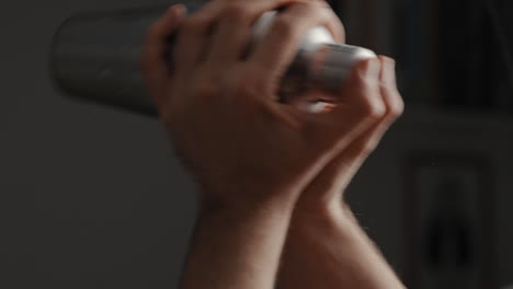 young male shaking a cocktail in a mixer at home in the kitchen. slow motion. close up
