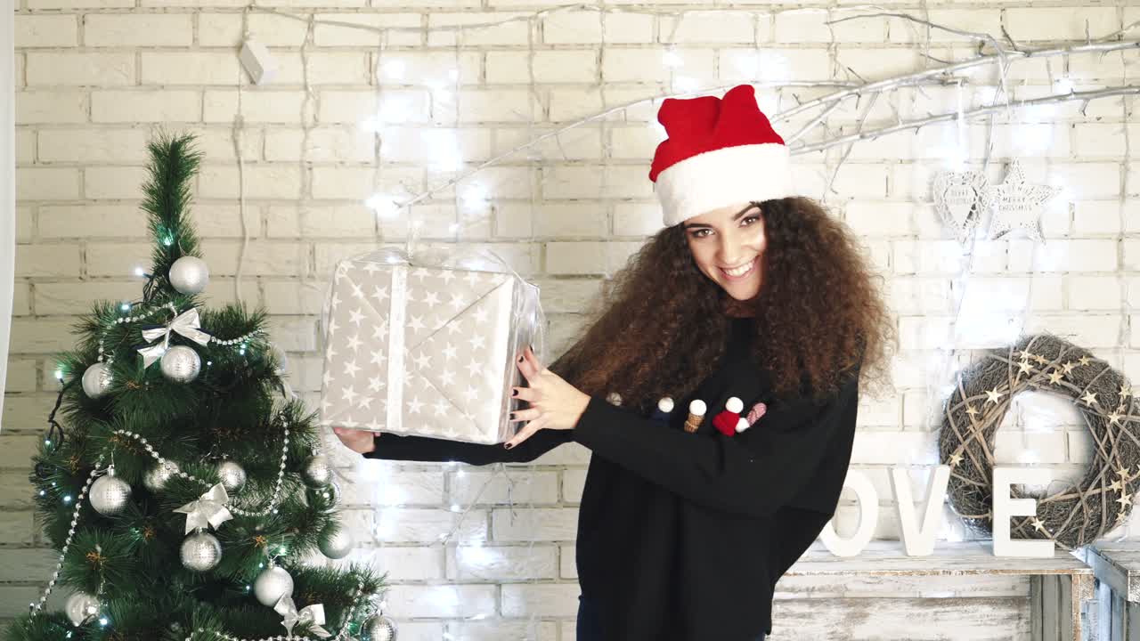 Woman opening gift boxes. Young woman with presents in New Year interior in the living room