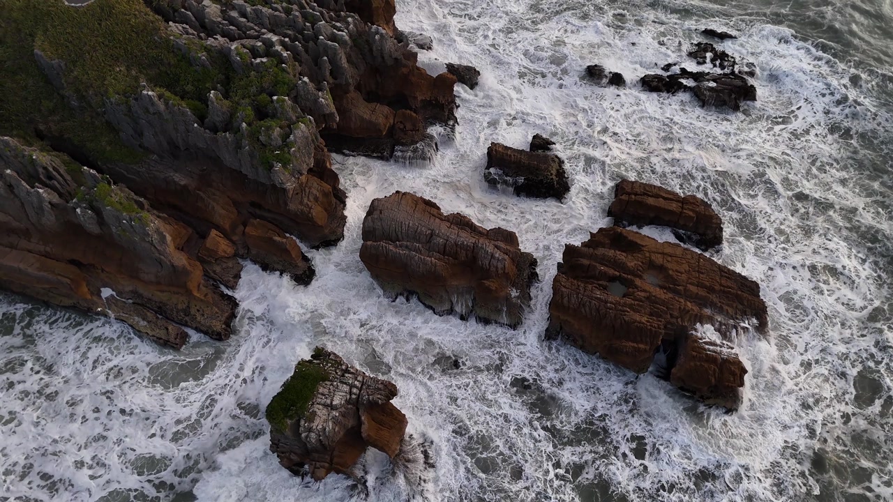 Top down drone view of the Pancake Rocks and the white foaming water on the South Island of New Zealand, near Punakaiki.