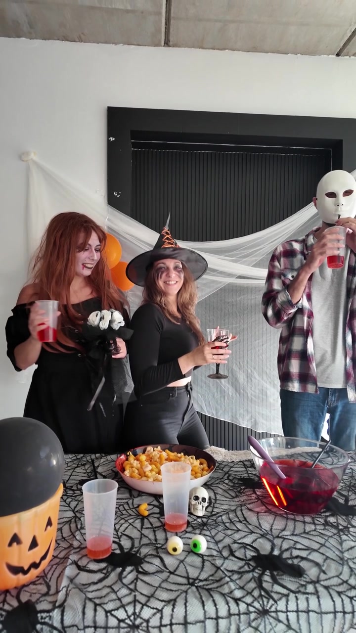 Kobieta podająca czerwony poncz na imprezie halloweenowej