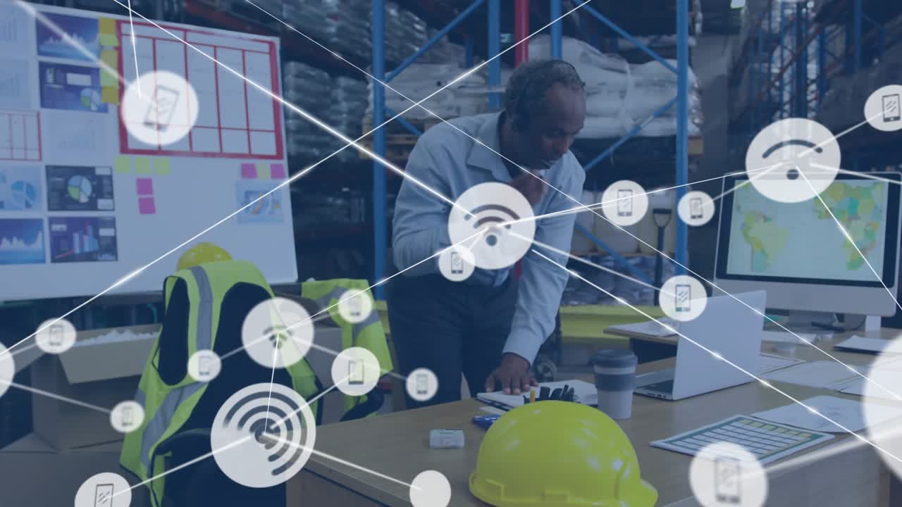 Warehouse supervisor reviewing laptop data WiFi icons expanding, calling for logistics monitoring