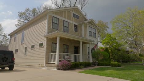 Push-towards-nice-house-in-the-suburbs-with-a-pan-towards-front-yard-and-street-on-a-spring-day