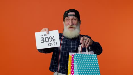 Elderly-bearded-man-showing-shopping-bags-and-Up-To-30-Percent-Off-inscriptions-text,-Black-Friday