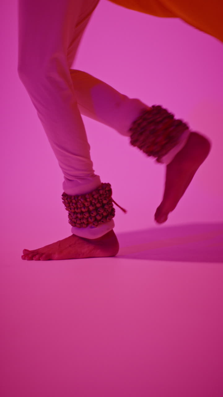 Vertical Video Close Up Of Feet With Bells Of Female Kathak Dancer Performing Dance Wearing Traditional Indian Dress Against Purple Background 4