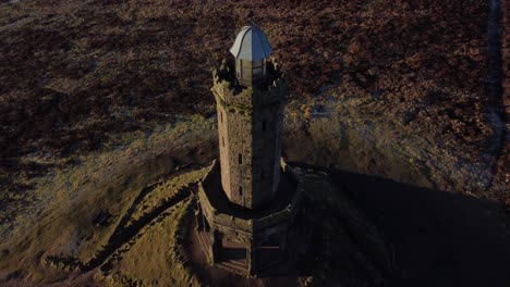 Aerial-birdseye-landmark-Darwen-Jubilee-tower-Lancashire-scenic-hillside-moorland-countryside-pull-back-tilt-up-to-horizon