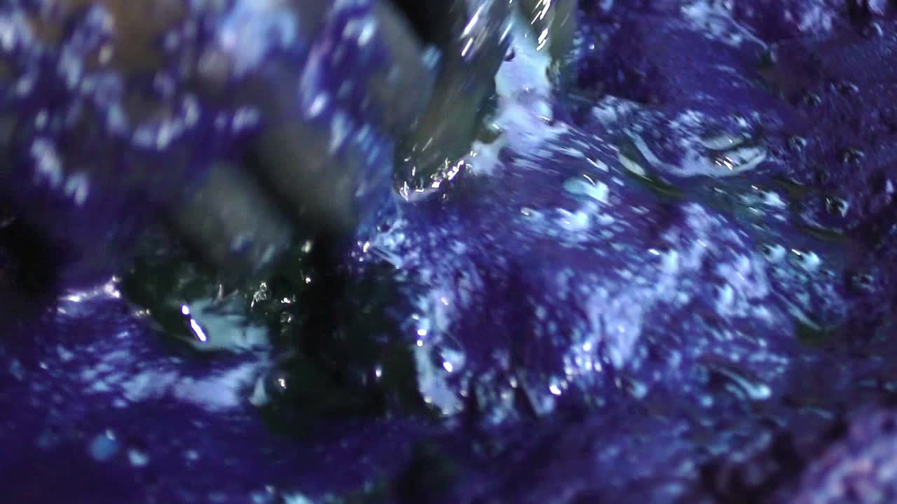 primer plano de las manos durante el proceso de teñido de textiles orgánicos en pakistán usando productos de polvo más loco