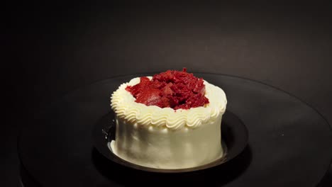 Mini-Pequeña-Porción-Personal-Pastel-De-Terciopelo-Rojo-Delicioso-Manjar-Sabroso-En-Una-Mesa-Giratoria-Fondo-Negro-Guarnición-Roja-En-La-Parte-Superior-Crema-Mantequilla-Afuera