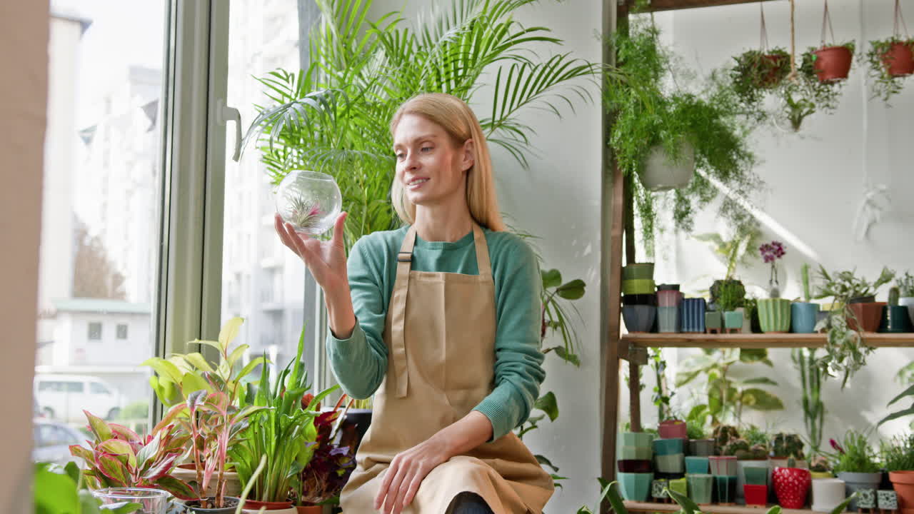 식물 가게 에서 테라리움 을 조사 하는 여자