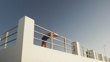 Senior-man-performing-stretching-exercise-on-the-promenade